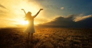 This is a photo of a woman raising her hands to the sun.