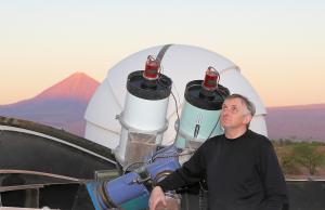 Alain Maury of the MAP survey in Chile posing with their telescope.