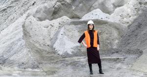 Photo of woman in PPE in front of aggregate.