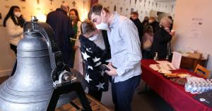 Congregation members inspect the newly-restored bell at Georgetown Lutheran Church.