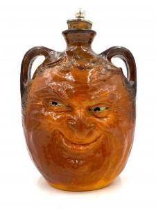 Double-handled face flask by R. W. Martin and Brothers (British, 1873-1914), made in 1901 and depicting a grinning character face ($12,300).