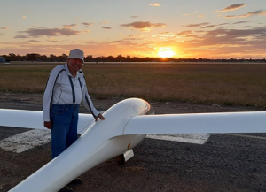 Ingo Renner stands with his glider at sunset