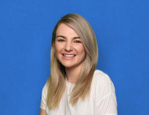 Portrait of Kait Schneider, VP of Strategic Partnerships at sherpa°