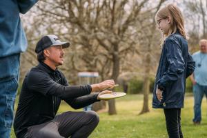 Professional disc golfer Paul Ulibarri signs a disc for a young fan