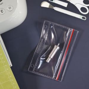 An extra blade for a die cutting machine inside a plastic binder pocket.