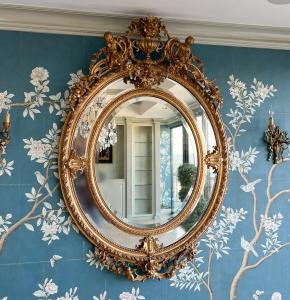 Large 19th century Louis XVI style giltwood mirror from the Beaux Arts period, having a crest and pendant with urn, putti and floral swags.