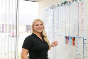 Female standing at a white board scheduling construction