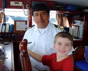 boy pilots ship in Galapagos