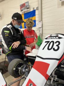 Father and son reading data next to go kart