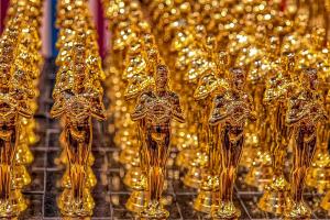 Rows of Oscar Statues lined up in front of a glittery background