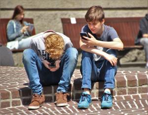 Distracted teens using smartphones while sitting on steps