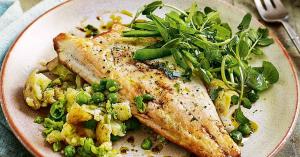 Fried sea-bass and vegetable mash with green salad, presented on a dinner plate