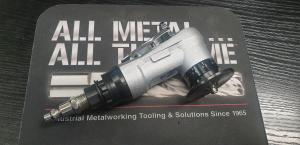 Picture of pneumatic chamfering tool to easily take an edge of many materials. Product shown on KBC logo.