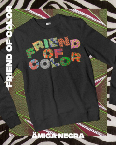 One black long sleeve shirt displayed. The wiords "Friend of Color" are written across with big bold letters. Each letter has beautiful african cloth filled in for each letter. There is a zebra frame on the photo.