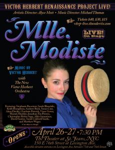 This photo is of a young white woman in a blue blouse with brown hair in a French twist. She is wearing a blue blouse and smiling at the camera and holding a men's straw hat from the early 1900's. This is a poster for Mlle Modiste at The Theater at St. Je