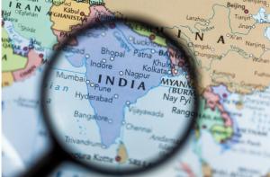 Magnifying glass over the country India on a colorful map