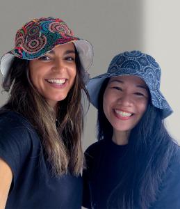 Model and WMB Studio Designer adorning their summer street style with Women's Body Dreaming and Bush Berry Ash Bucket Hat from the Signature Collection.