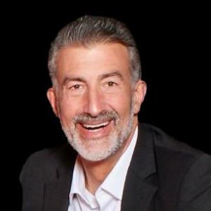 Ben Benedetti's headshot: a smiling man with gray hair and beard wearing a suit, in front of a black background