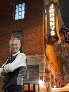 Piano man Mike Petrone standing in front of the Johnny's Downtown sign in Cleveland, where he has performed for 6,000 nights.