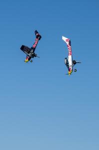 Two Red Bull planes nose-diving in the sky towards the ground