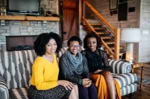 Authors & Podcast Co-Hosts (right to left) Christina Edmondson, Michelle Higgins and Ekemini Uwan posing together on couch