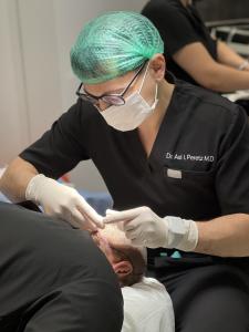 Dr Asi Peretz performing FUE hair transplantation at Trichogenics surgical center