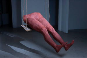 Sculpture of lower half of the body, hanging on a swing.