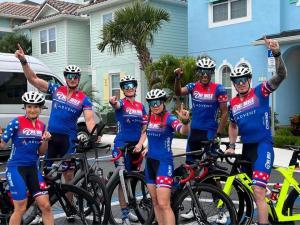 Bike riders, wearing red white and blue outfits excited for a race.