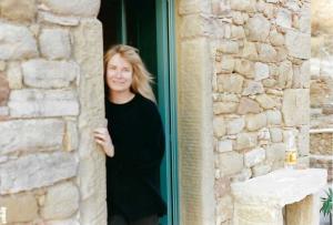 This images shows the author standing in the doorway of one of her restored Italian villas in Umbria, Italy.