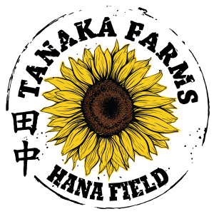 Circle with the words Tanaka Farms Hana Field and a drawing of a sunflower in the center.
