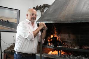 "Family Dinner" host Andrew Zimmern poses by the fire while cooking with the Doffo Family