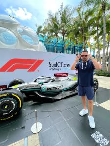 Paul Vigario adjusts his shades while he stands in front of a Formula 1 race car at the Formula 1 Crypto.com Miami Grand Prix event that took place May 6-8, 2022