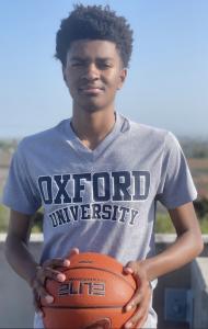 Youth Feel Founder Owen Kirk smiling and holding a basketball, wearing an Oxford University shirt.