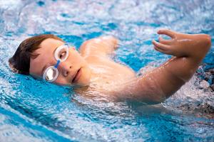 young male adaptive athlete swimming in the pool