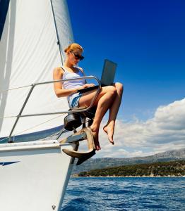 Young woman sit on a boat working on her laptop