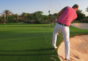 golfer trying to get out of the bunker on the golf course