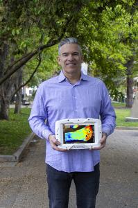 CEO of Kent Imaging, Pierre Lemire, posing with the SnapshotNIR camera-like device outside in park, Calgary Alberta