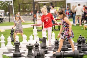 Children play with the giant chess set at D-Luxe Properties