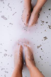 Two pairs feet in a bath of Life Elements Cooling Foot Soak