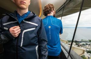 Employees model new rain jacket and polo in the The Loupe of the Space Needle