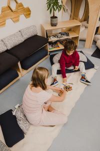 Children sitting on a rug on the floor making a puzzle.
