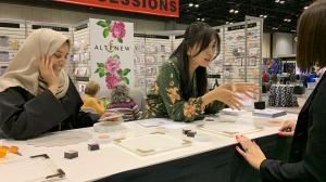 Altenew representatives demonstrating how to use the Stampwheel at the annual NAMTA Creativation tradeshow in April 2022.