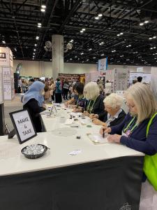 Dozens of crafters were free to try out the Stampwheel for the first time at the Altenew booth in this crafting convention.