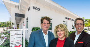 John Gonzalez (right) welcomes new partners Dan and Shelly Hammer at the Engel & Vőlkers office in Stuart, Florida.