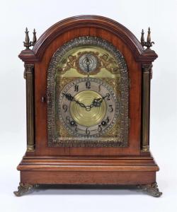 19th century Tiffany & Co. Westminster bracket mantel clock with a wood case and four brass finials housing a face depicting putti and tendril elements (est. $2,500-$3,500).