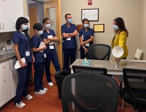 Group of eye doctors in blue scrubs and masks in a training room