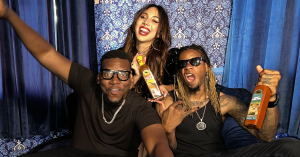 Three-time international award-winning U.S. hip hop duo Banded Future poses with Colombian singer Shelly during the filming of their new music video for their song "Sauce," while holding video sponsor African Dream Foods' sauces.