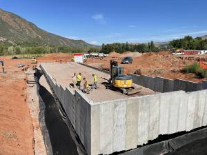 Construction on distillery site with mountains in background.