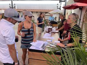 A man and woman talking to winemaker Susan Mahler and tasting her wines at the OC Fair.