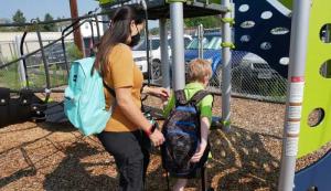 FireFly Autism team member with student on playground